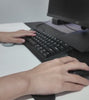 Ruka na myši opřená o silikonovou podložku ErgoMouse při práci u počítače